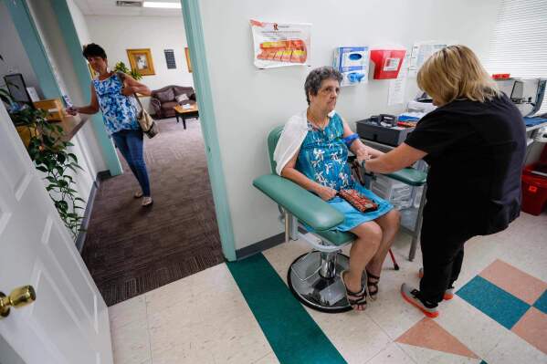 Faye Jackson gets her blood tested at a medical clinic in Calhoun, Ga., on Tuesday, Sept. 30, 2025, as her daughter Marie waits outside for her turn. Their blood tests revealed they have PFAS levels above the safety threshold outlined by national health experts. (Miguel Martinez/Atlanta Journal-Constitution via AP)