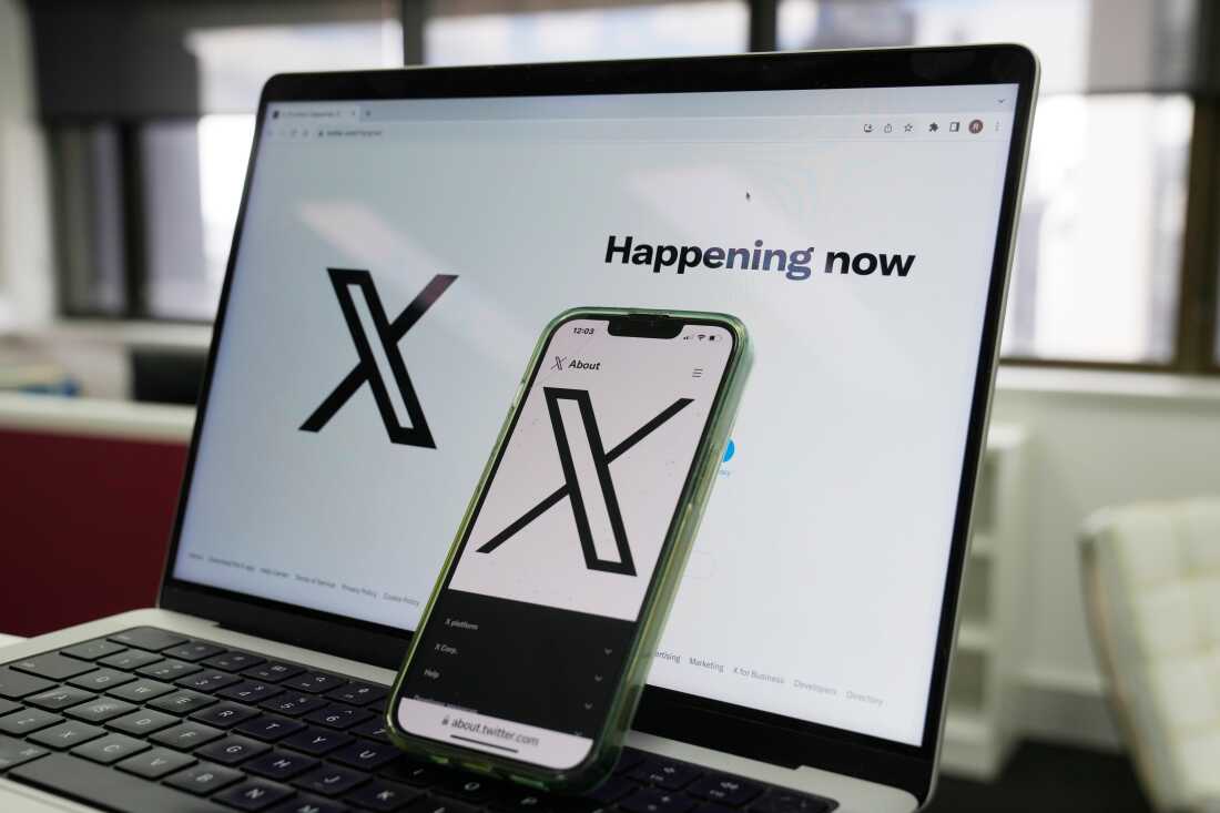 The opening page of X is displayed on a computer and phone, Oct. 16, 2023, in Sydney.