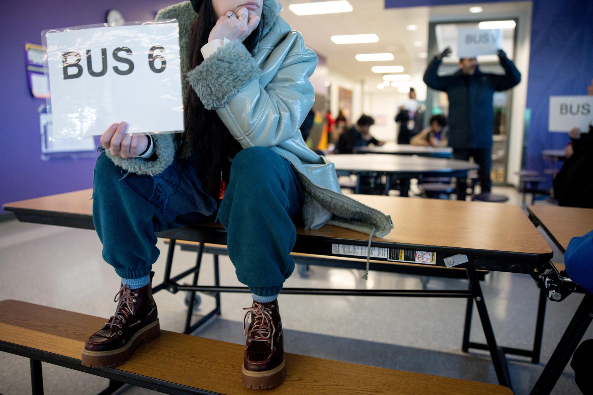 a staff member holds a sign for a bus