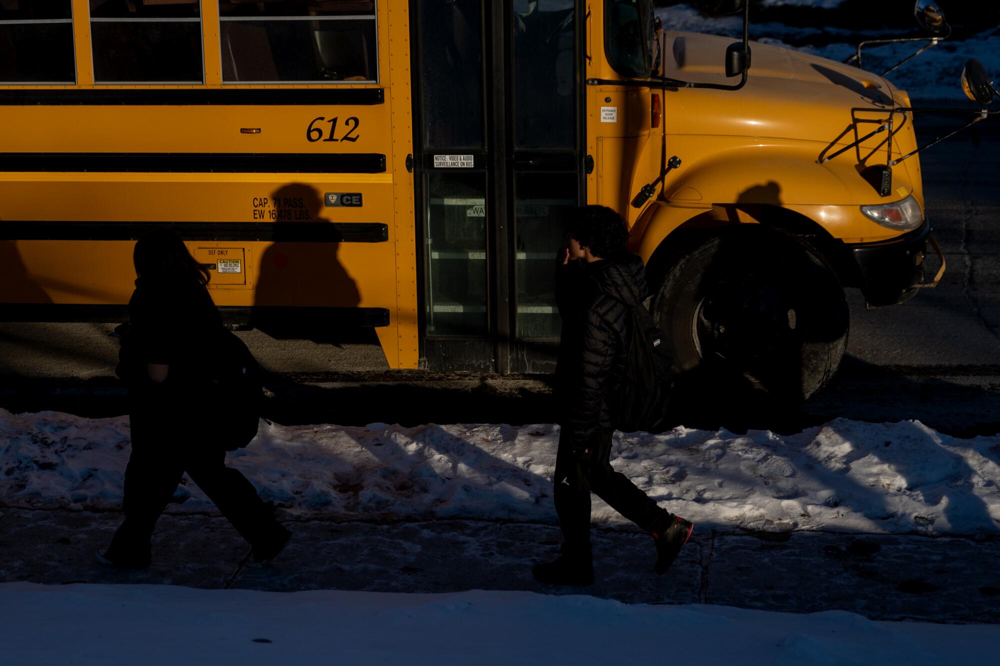 Students walk to a bus 