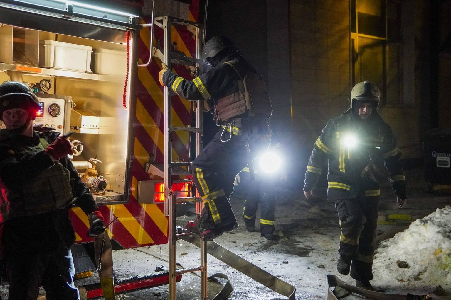 Ukrainian emergency workers stand at the site of an apartment building damaged in a Russian air attack in Kyiv, Ukraine, early on Feb. 3, 2026.