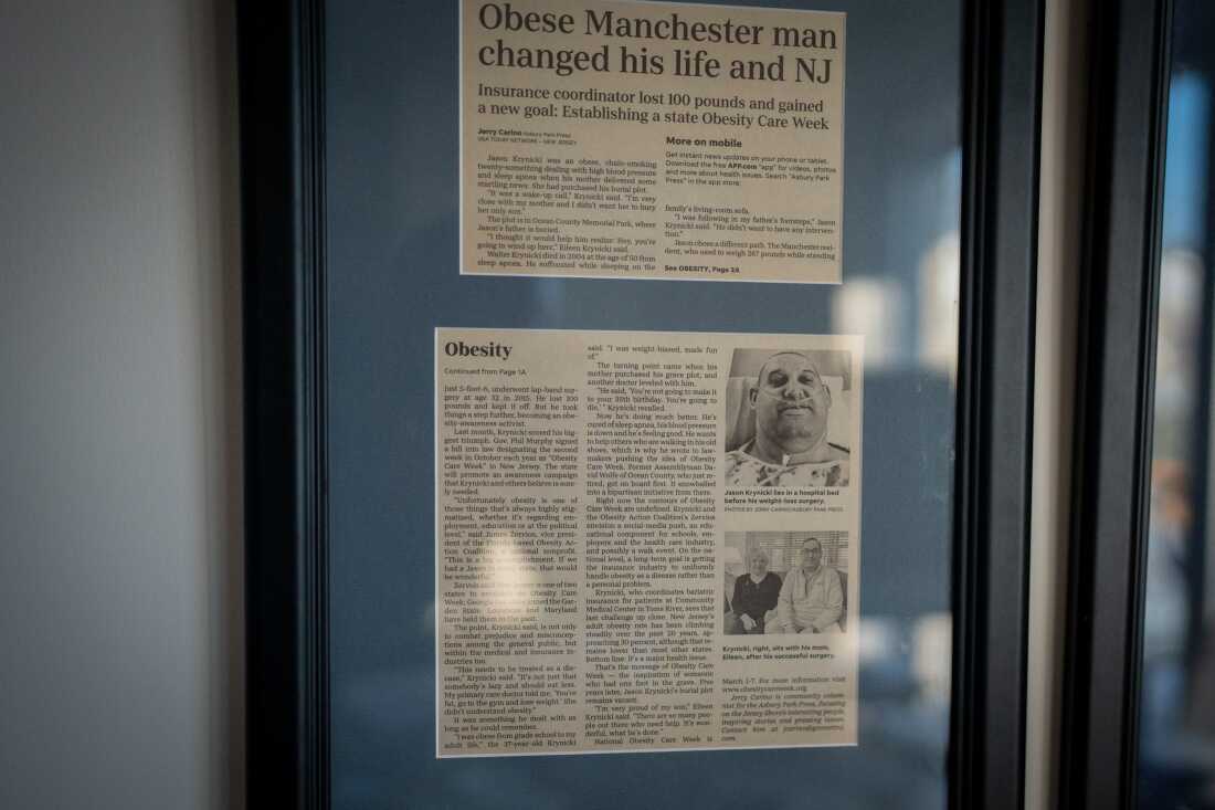 A framed article about Jason Krynicki and his efforts to get bariatric surgery covered in New Jersey hangs in his living room.