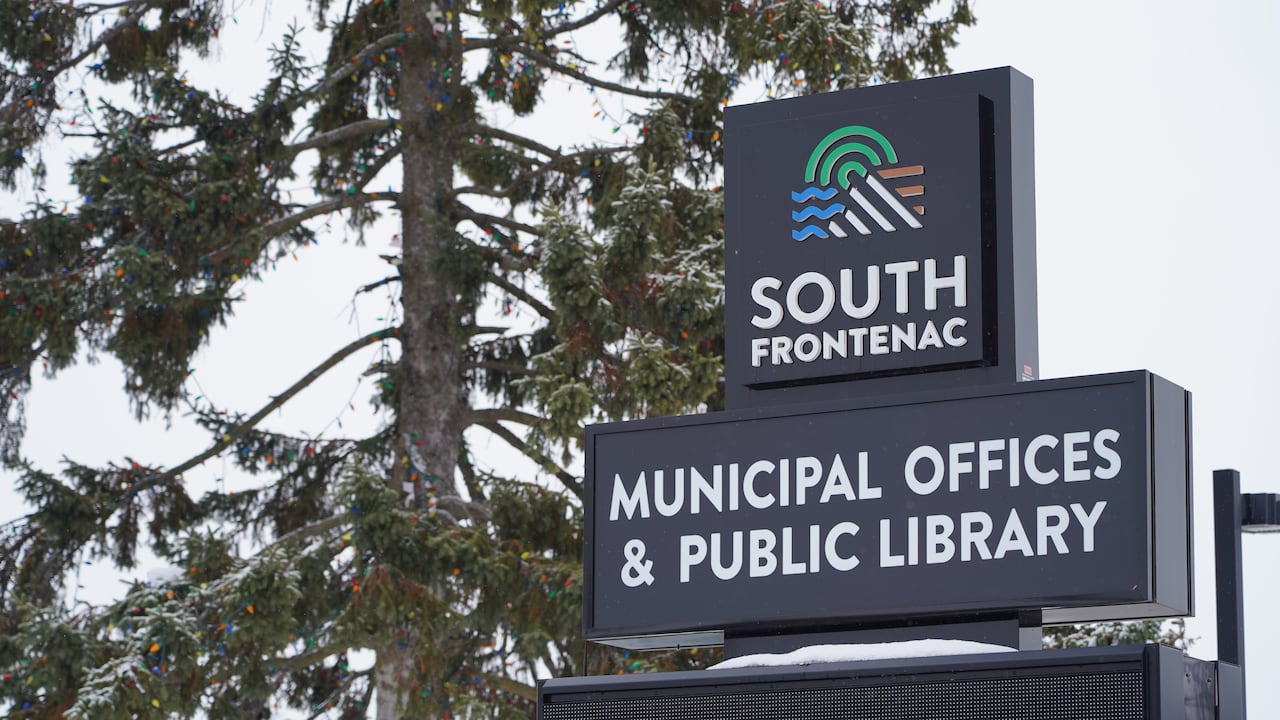 A black sign with a green, blue and brown logo.