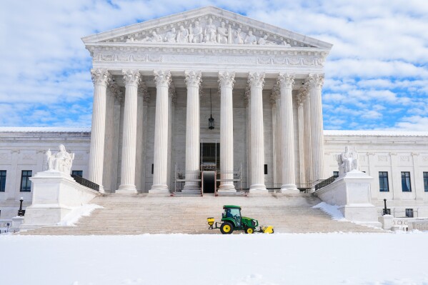 A worker clears snow at the U.S. Supreme Court after a snowstorm Monday, Jan. 26, 2026, in Washington. (AP Photo/Mariam Zuhaib)