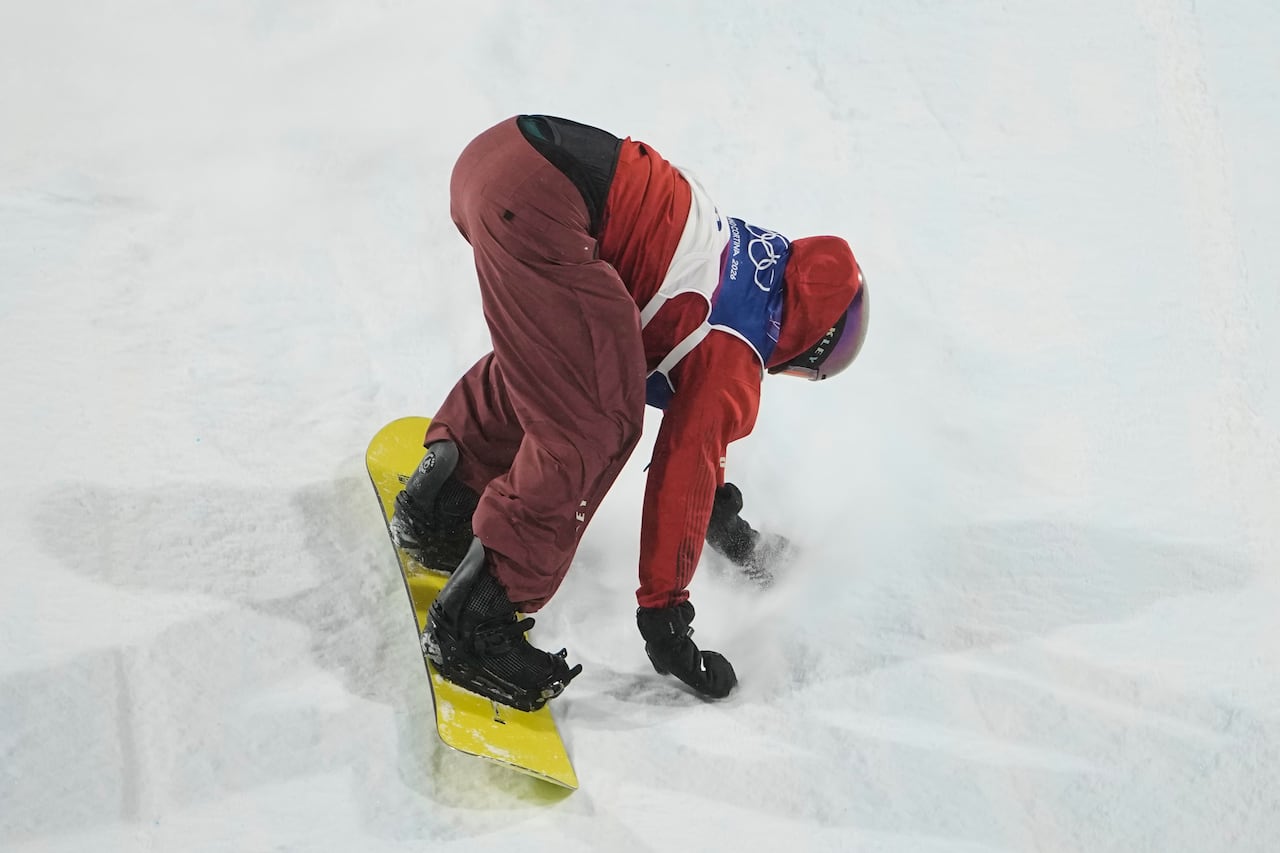 A snowboarder lands a jump.
