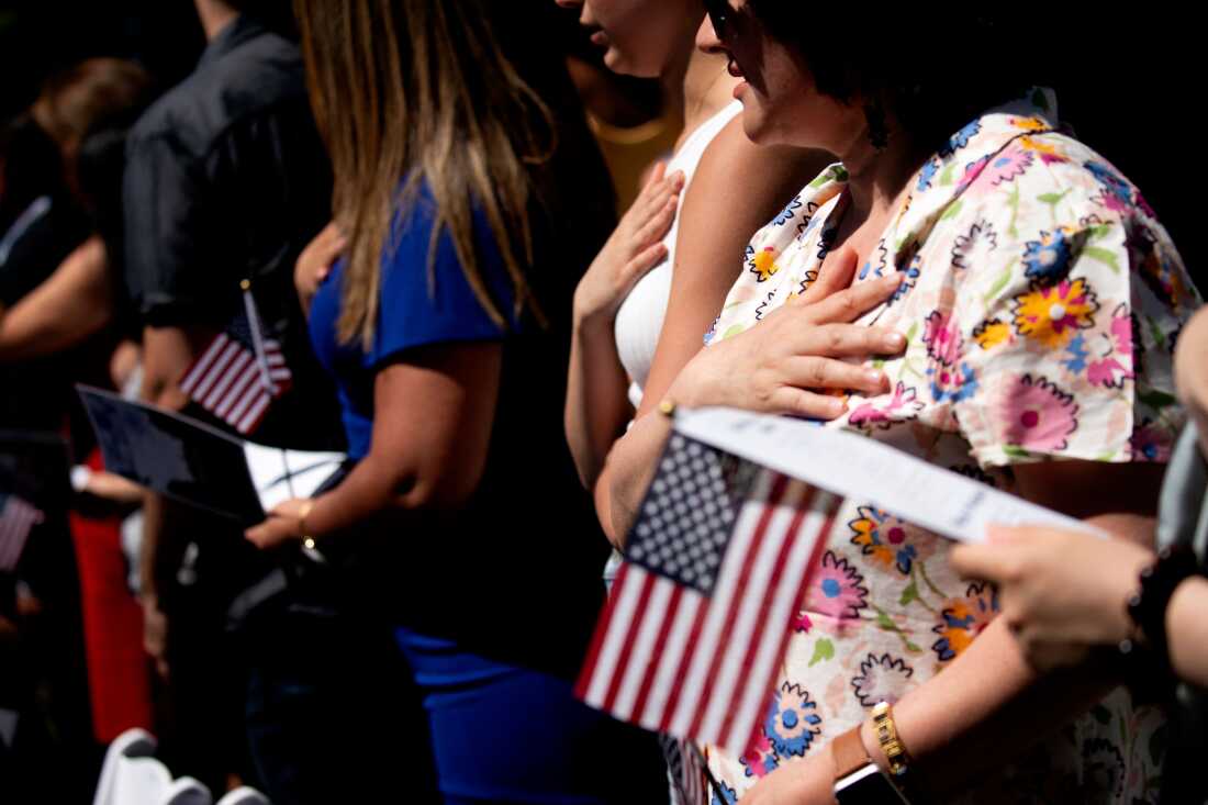 New U.S. citizens recite the Pledge of Allegiance during their naturalization ceremony in Mount Vernon, Va., in 2022.