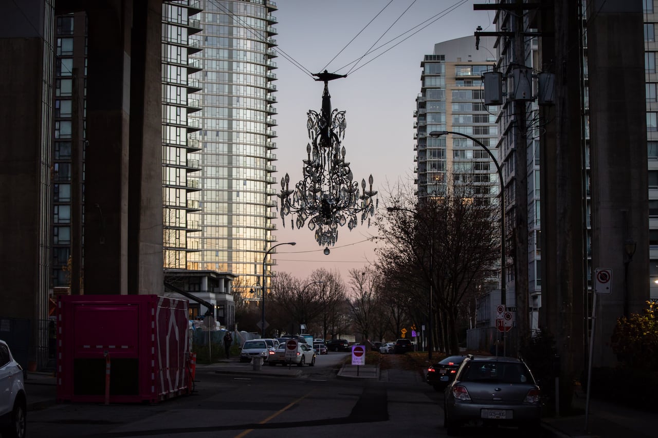 A giant chandelier hangs under a bridge. 