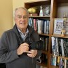 John Biever poses with a camera in front of some memorabilia at his San Diego home.