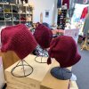 Handmade red "Melt the ICE" hats are on display at Minneapolis yarn store Needle & Skein.