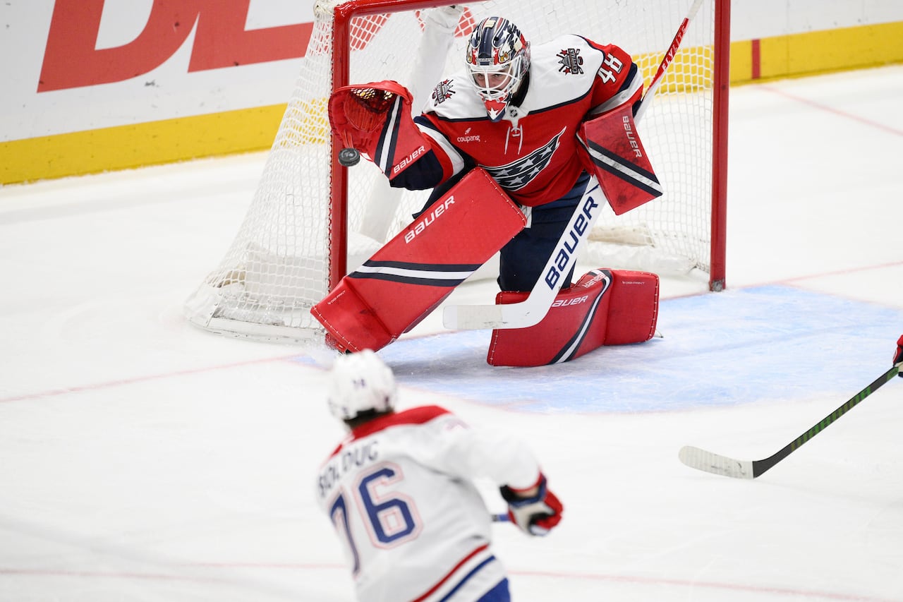 A hockey goaltender makes a save.