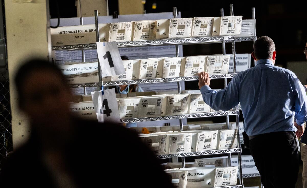 An election worker moves ballots to be sorted.
