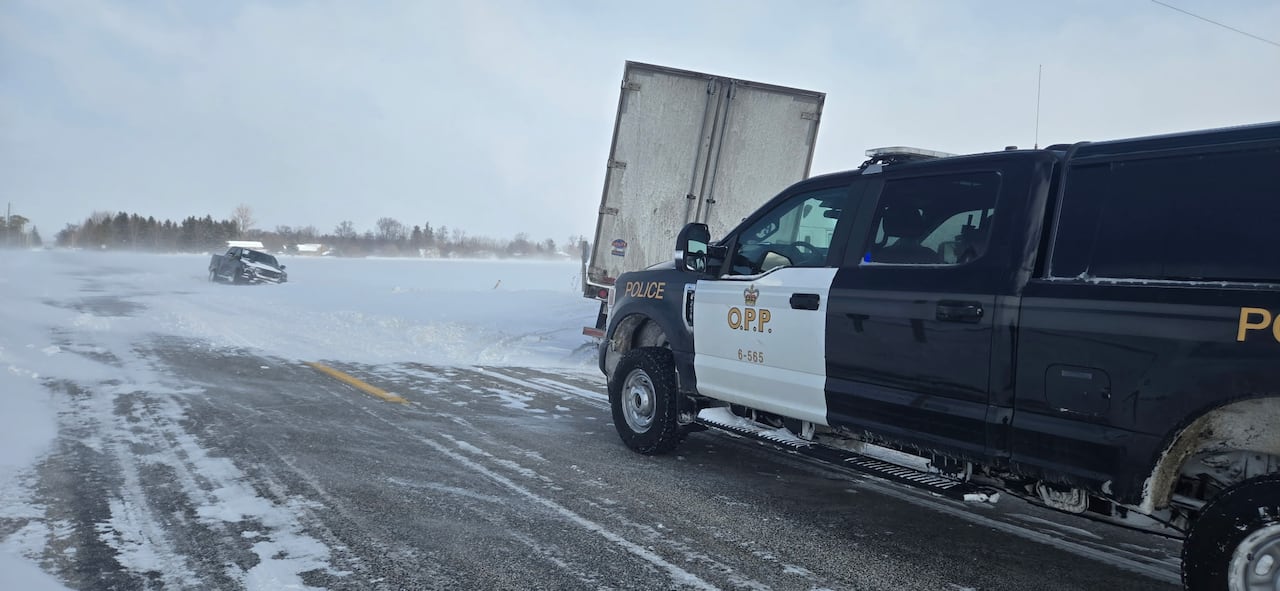 Police car nearby tow truck and pickup truck stuck in snow