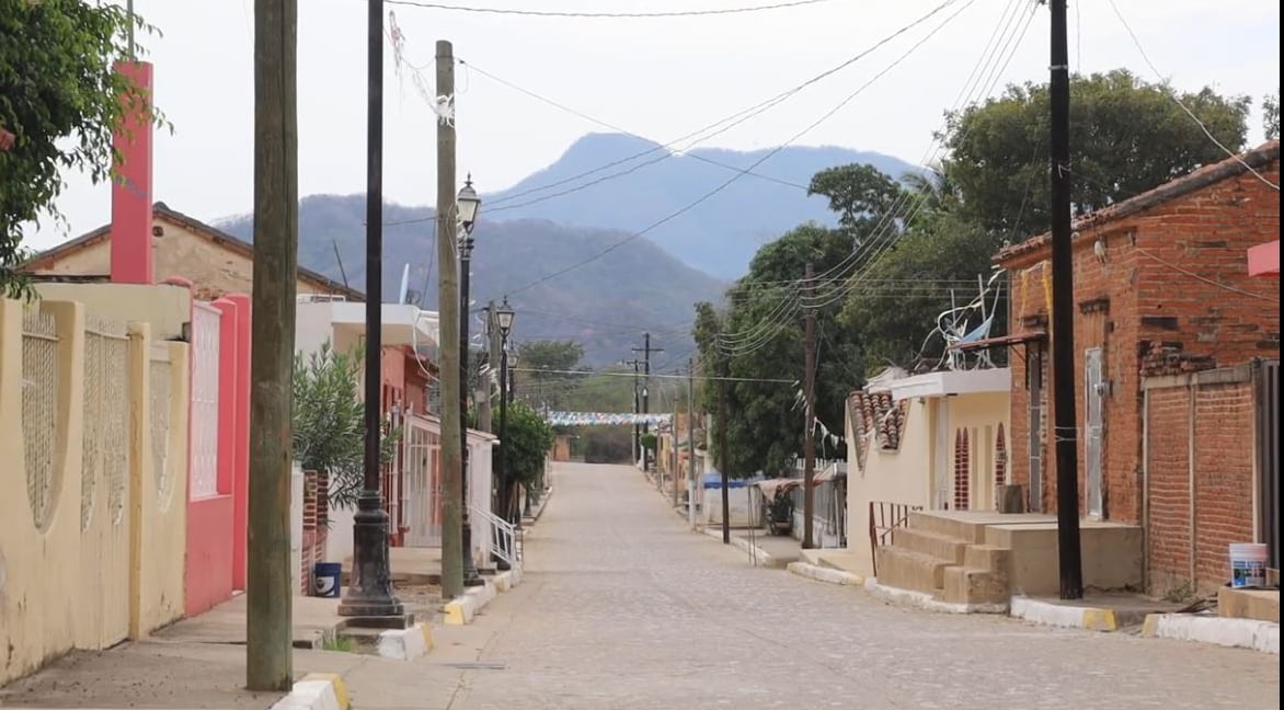 An empty street with mountains in the distance.