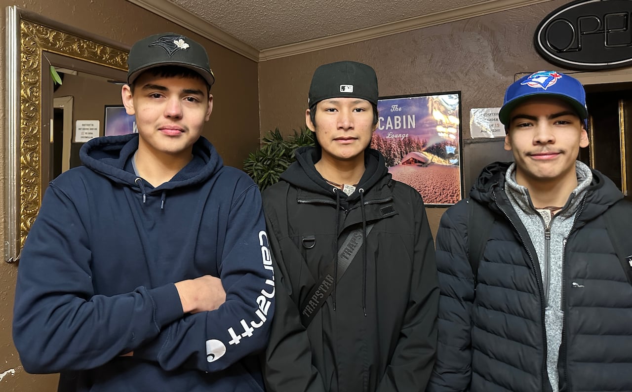 Three teenagers in a dark hallway.