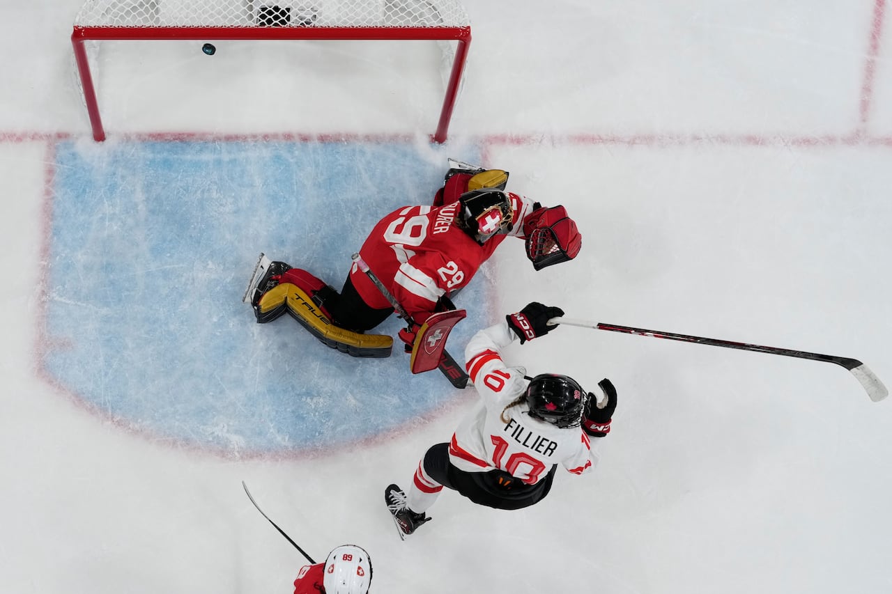 An overhead view of a hockey player scoring a goal.