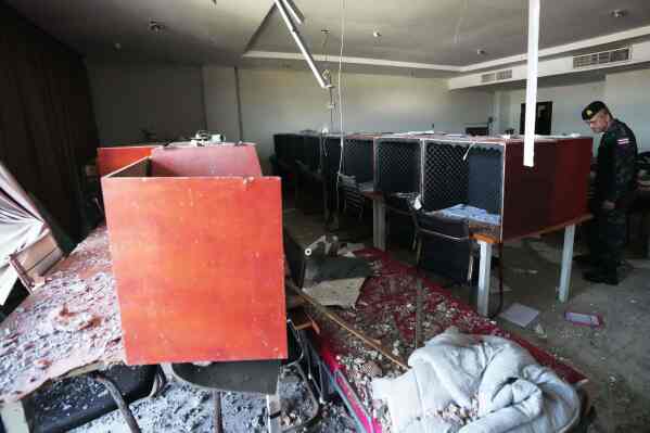 A Thai soldier inspects a work station with wooden phone booths lined with foam for soundproofing, inside a scam compound in O'Smach, Cambodia, Monday, Feb. 2, 2026. (AP Photo/Sakchai Lalit, File)