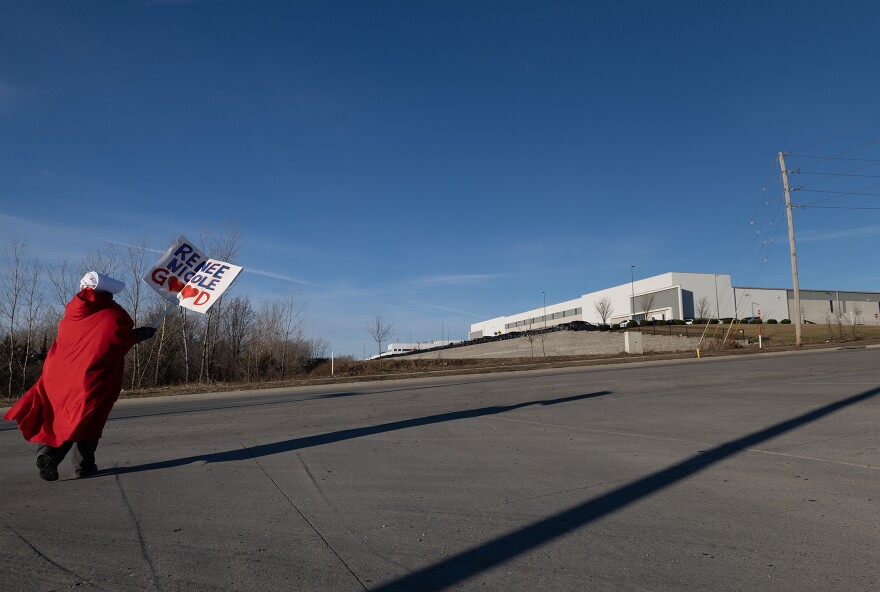 A member of the KC Handmaid Army heads towards an industrial warehouse park to protest a mass ICE detention facility in Kansas City, Missouri.