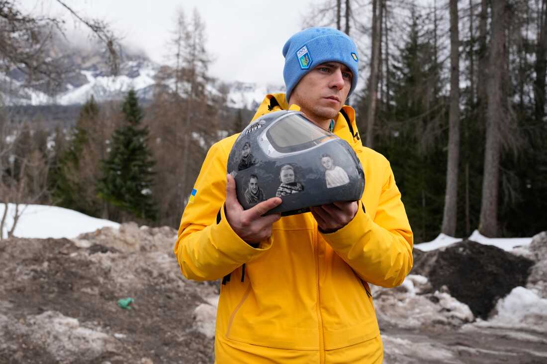 Ukrainian skeleton athlete Vladyslav Heraskevych holds his crash helmet as he stands outside the sliding center at the 2026 Winter Olympics, in Cortina d'Ampezzo, Italy, Thursday.