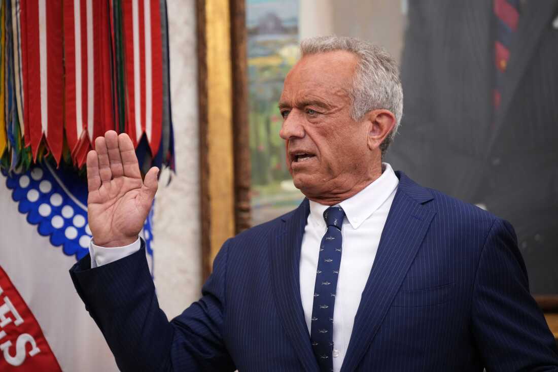 Robert F. Kennedy Jr. raises his hand at his swearing-in.