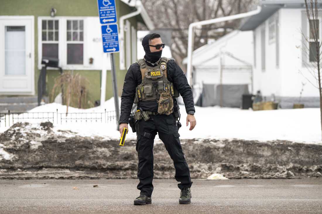 An ICE agent holds a taser as they stand watch on February 5, 2026 in Minneapolis.