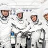 The four members of NASA’s SpaceX Crew-12 mission stand with a "hands in" pose while wearing their spacesuits.