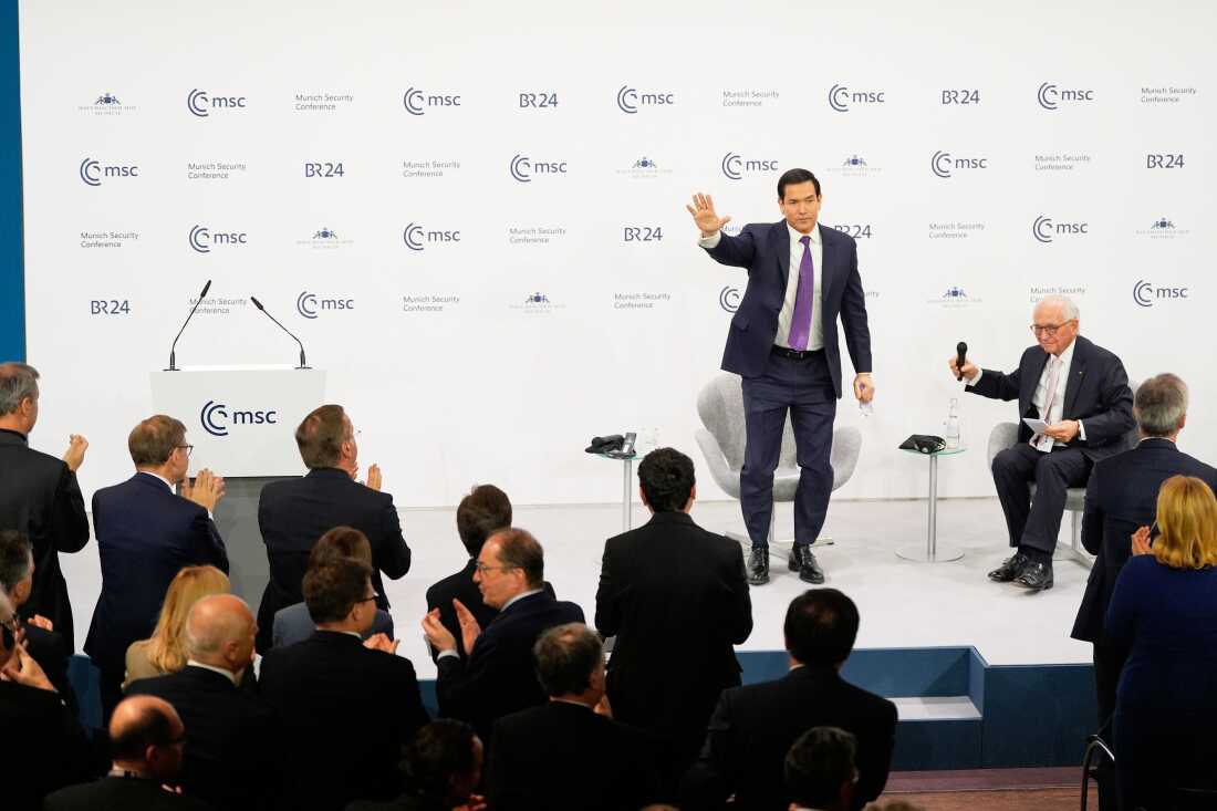U.S. Secretary of State Marco Rubio waves, next to Chairman of the Munich Security Conference Wolfgang Ischinger, as he gets a standing ovation after his speech at the Munich Security Conference in Munich, Germany, on Saturday