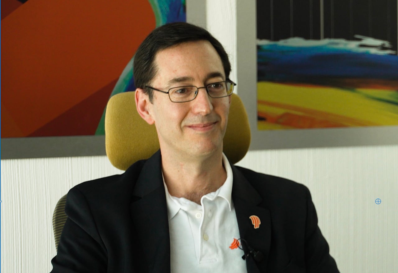 A man with glasses talking.