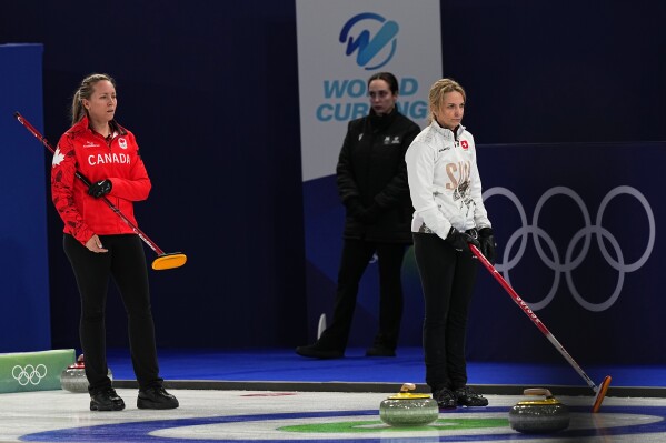 Canada's Rachel Homan and Switzerland's Silvana Tirinzoni compete during the women's curling round robin session at the 2026 Winter Olympics, in Cortina d'Ampezzo, Italy, Saturday, Feb.14, 2026. (AP Photo/Fatima Shbair)