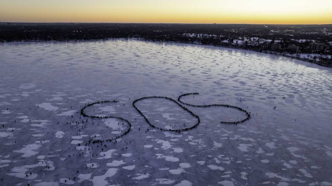 In this aerial photo, demonstrators in Minneapolis stand on a frozen lake and have arranged their positions to spell out the letters "SOS" when viewed from the air.