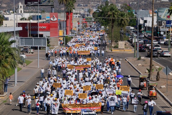 Relatives and friends of 10 mine workers who were abducted last month in neighboring Sinaloa state, march demanding justice, in Hermosillo, Mexico, Saturday, Feb. 14, 2026. (AP Photo/Luis Gutierrez)