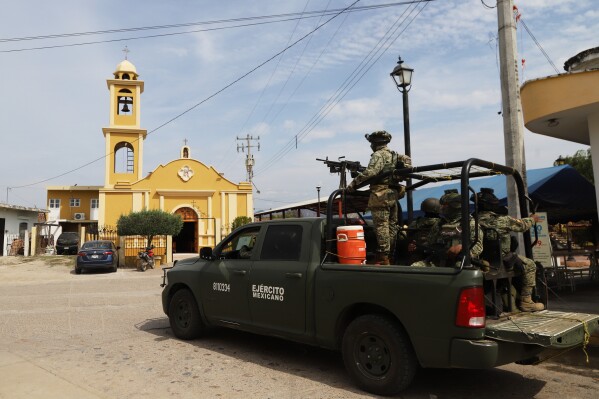 Soldiers stand guard near a church in El Verde, Sinaloa state, Mexico, Monday, Feb. 8, 2026. (AP Photo/Juvencio Villanueva)