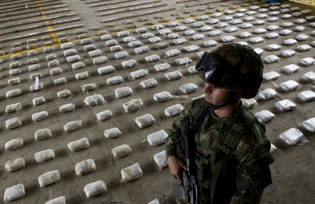 A Colombian Army soldier stands next to packages of seized cocaine during a press conference at a Military Base in Bahia Solano, department of Choco, Colombia, on March 14, 2015.