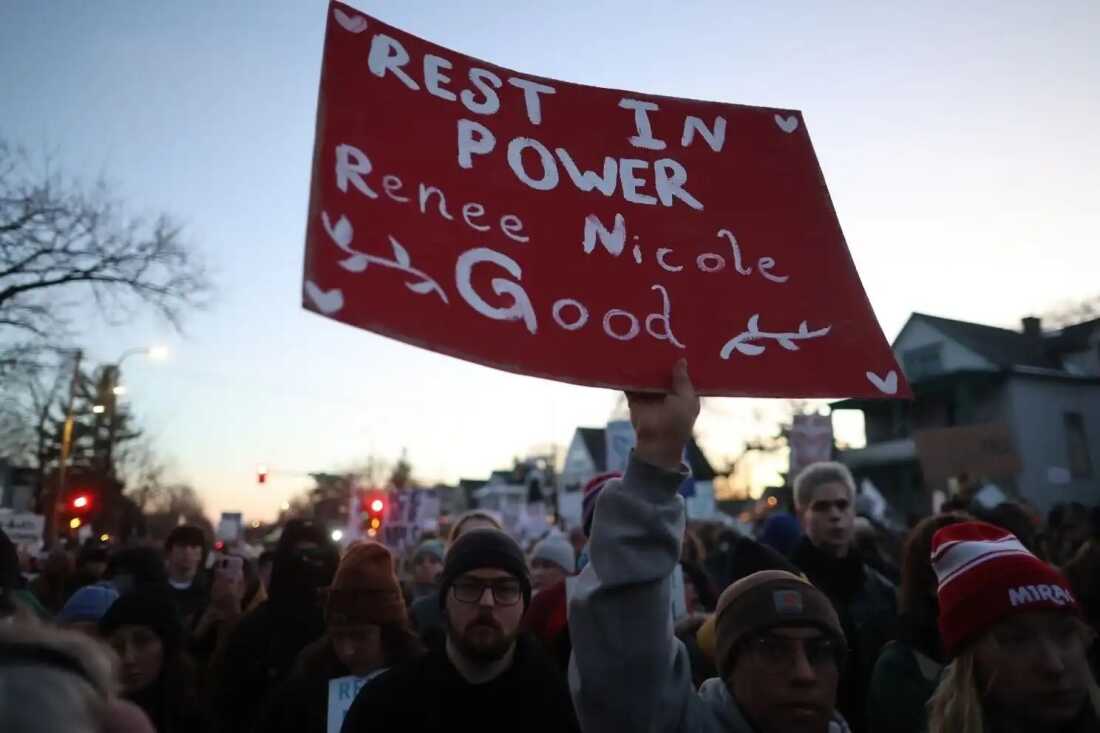 A demonstrator carries a sign honoring the life of Renee Macklin Good on Jan. 9 in Minneapolis.