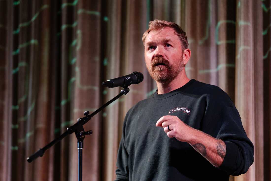 Standing in front of a microphone, U.S. senatorial candidate Graham Platner of Maine speaks at a town hall on October 22, 2025, in Ogunquit, Maine.