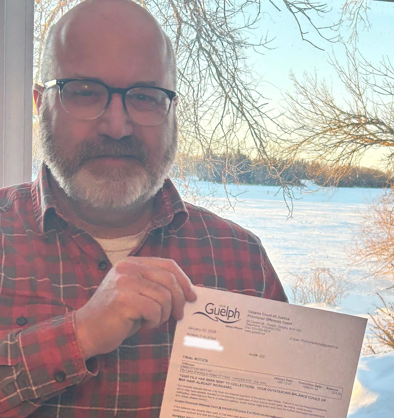 A man holds up a letter telling him it's his final notice for a parking ticket fine