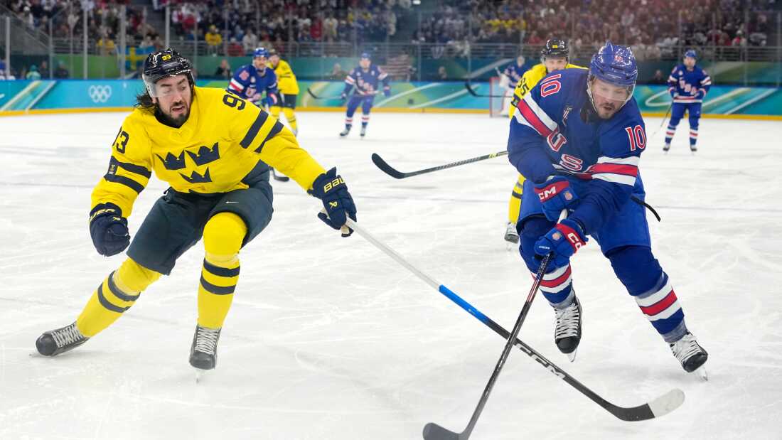 Sweden's Mika Zibanejad (93) and United States' JT Miller (10) chase the puck during the third period of a men's ice hockey quarterfinal game at the 2026 Winter Olympics, in Milan, Italy, Wednesday, Feb. 18, 2026. (AP Photo/Hassan Ammar)