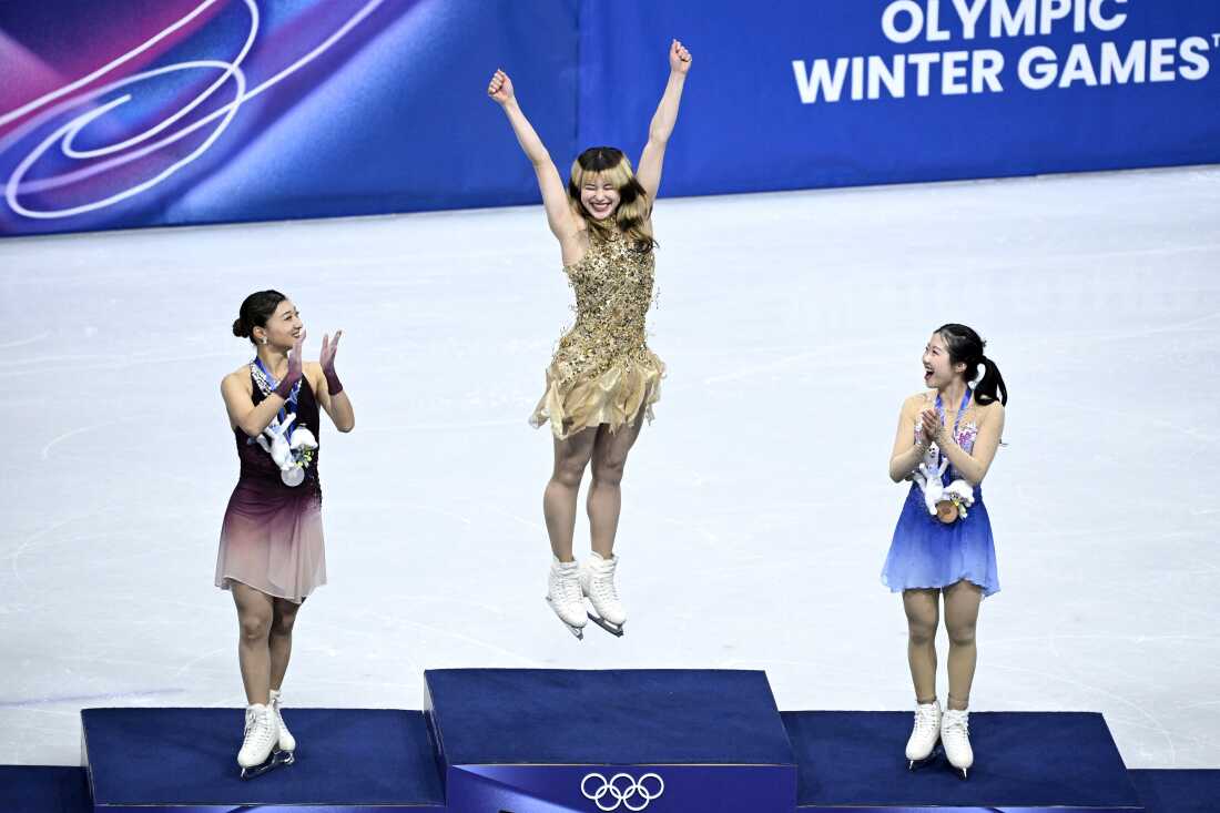 Alysa Liu (C) celebrates next to silver medalist Kaori Sakamoto (L) and bronze medalist Ami Nakai (R), both of Japan.