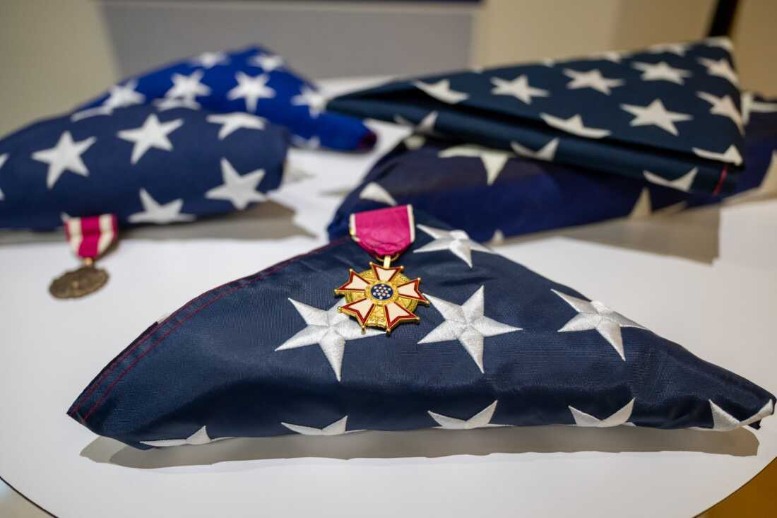 Folded U.S. flags rest on a table at a retirement ceremony for transgender service members in Washington, D.C.