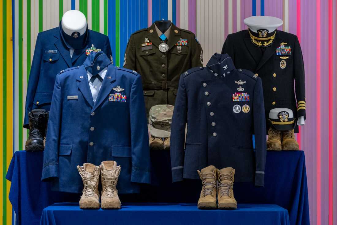 To the left of the stage is a table of mannequins dressed in the retirees’ uniforms. Trans service members were prohibited from wearing their uniforms during their retirement ceremony.