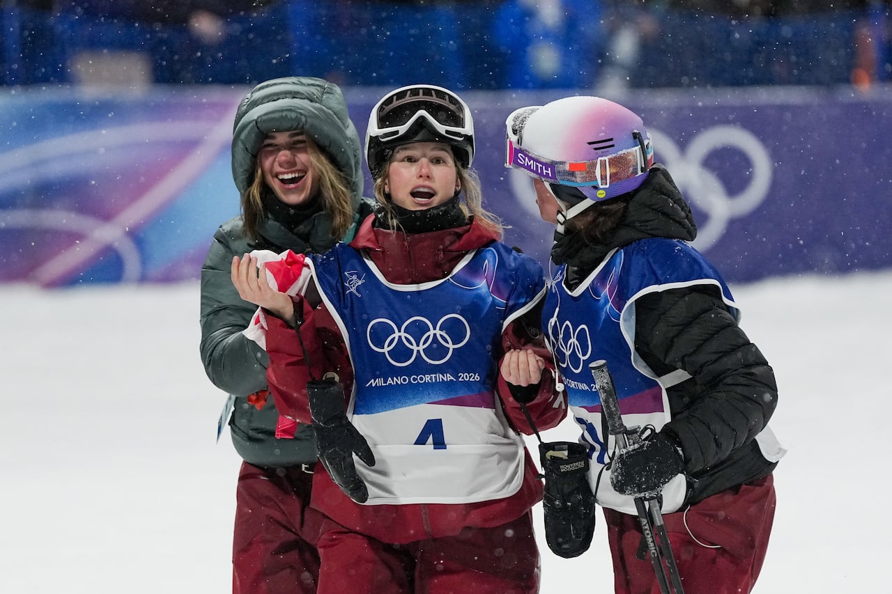 A skier is congratulated by teammates.