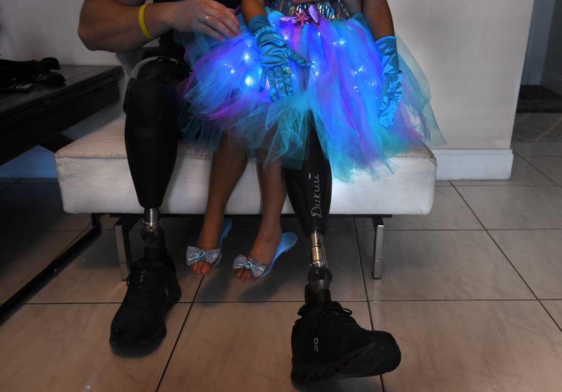 Sgt. Misha Varvarych, a Ukrainian war amputee, holds the child of a volunteer for the nonprofit Revived Soldiers Ukraine