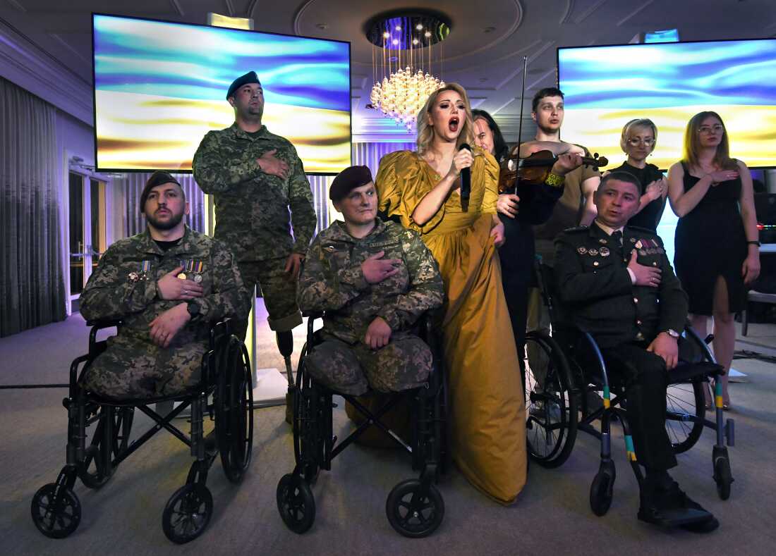 Sgt. Misha Varvarych, a Ukrainian 80th Airborne Assault Brigade commander attends a fundraiser gala in full uniform for Revived Soldiers Ukraine in Orlando FL on February 4, 2023. He and fiancé Ira Botvynska, traveled to the US to receive rehabilitation and state-of-the-art prosthetics with assistance from the nonprofit made possible by the kindness of others. He formed bonds with the other soldiers as they laughed and struggled together while sharing group homes. They got a little tipsy on this special night. A Ukrainian opera singer performed and an auction of goods including twisted metal from the war made into sculptures that garnered donations. Next to Misha is Andrii Nasada who lost both his legs, has mangled fingers, severely damaged eyes, and deep black powder scars on his face. Far right, bottom row is Ruslan Tyshchenko. Back left is Denis Kuznetsov.. Back right is Vladyslav Zhaivoronok.