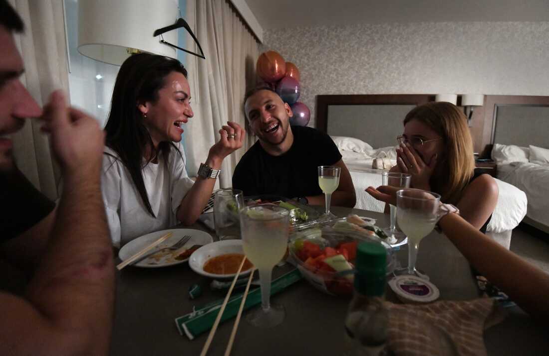 Varvarych and Botvynska (center and right) celebrate after his marriage proposal, in Orlando, Fla., on April 15, 2023. Yaryna Levytska (left) fled the war in Ukraine but returns with her daughter Leila every summer to visit her parents who won't leave.