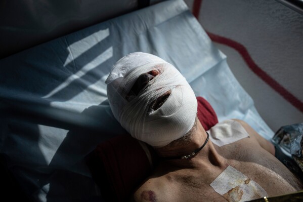 A wounded Ukrainian soldier lies in a medical evacuation bus run by volunteers from the Hospitallers paramedic organization in Donetsk, Ukraine, on Wednesday, March 22, 2023. (AP Photo/Evgeniy Maloletka, File)