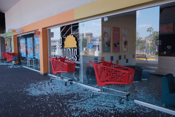 Carts stand outside of a vandalized supermarket in Guadalajara, Jalisco state, Mexico, Sunday, Feb. 22, 2026, after the death of the leader of the Jalisco New Generation Cartel, Nemesio Rubén Oseguera Cervantes, known as "El Mencho." (AP Photo/Alejandra Leyva)