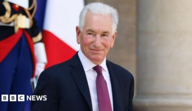 Charles Kushner smiles while leaving the Elysee Palace
