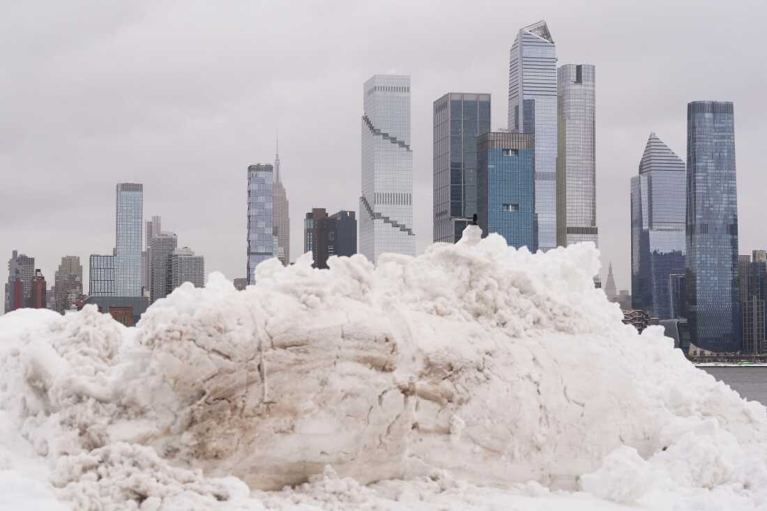 A piece of the New York skyline rises above a pile of snow on the Weekhawken, N.J. waterfront, Monday, Feb. 23, 2026.