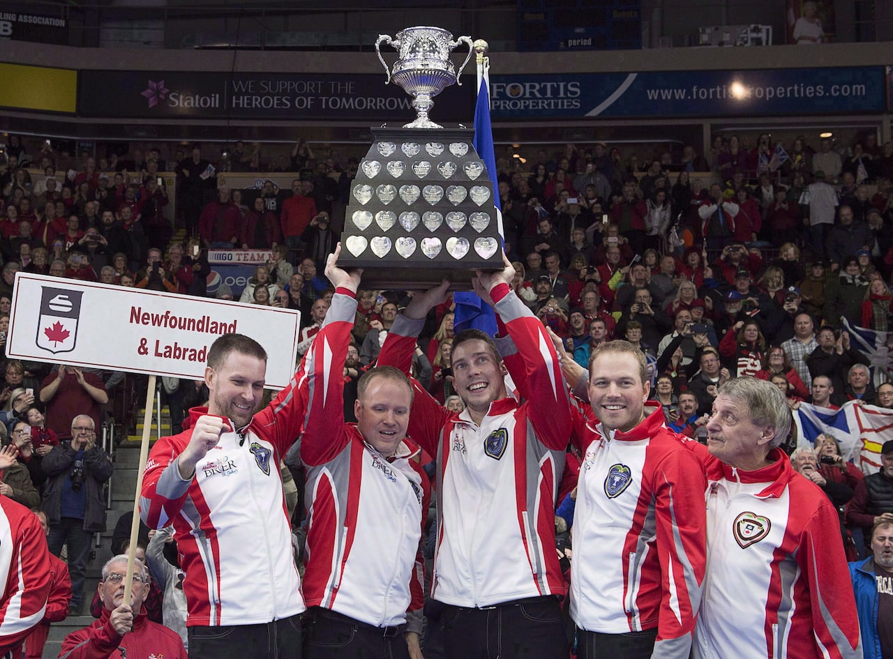 A curling team holding up a trophy.