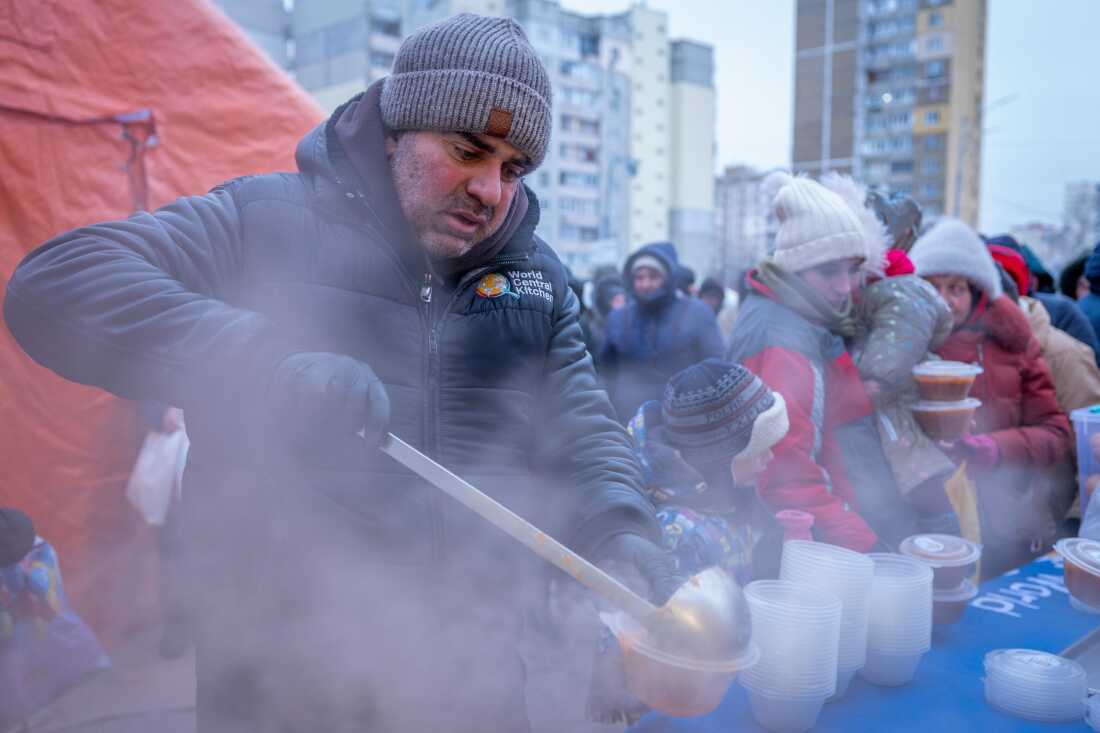 People who have no power at home following Russia's air attacks wait in line to receive free hot meals in a residential neighborhood in Kyiv on January 30.
