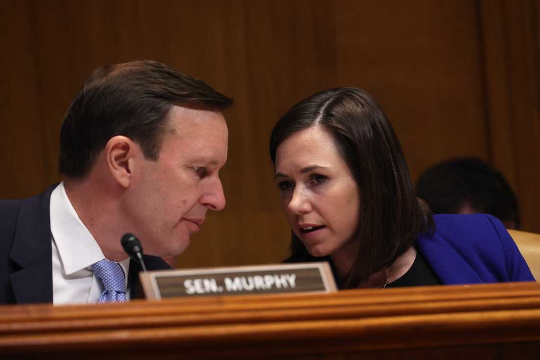 Sen. Chris Murphy, D-Conn., talks to Sen. Katie Britt, R-Ala., during a March 29, 2023 hearing on Capitol Hill.